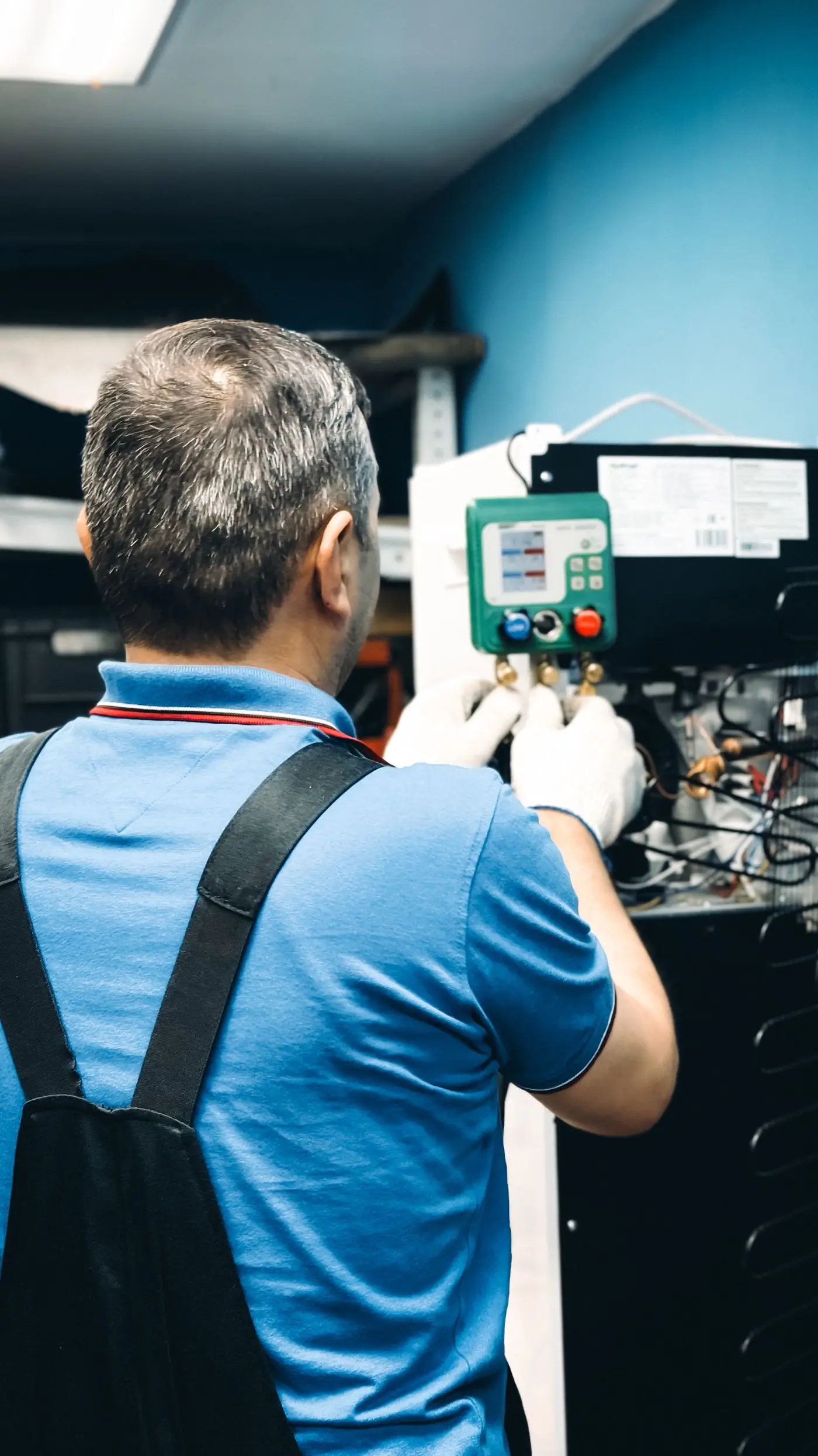 A technician servicing an indoor air conditioning unit