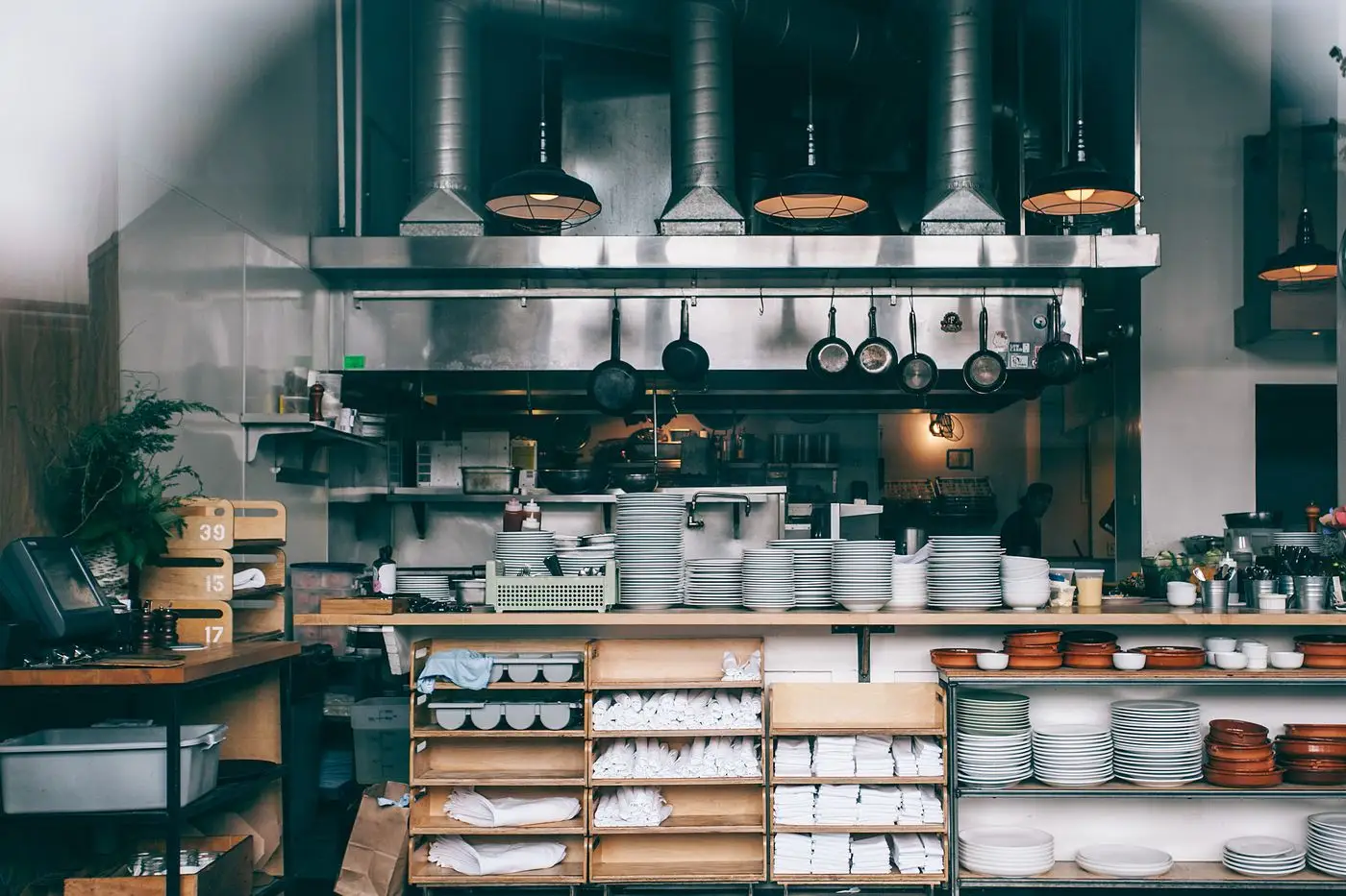 A restaurant kitchen pass stacked with plates ready for service