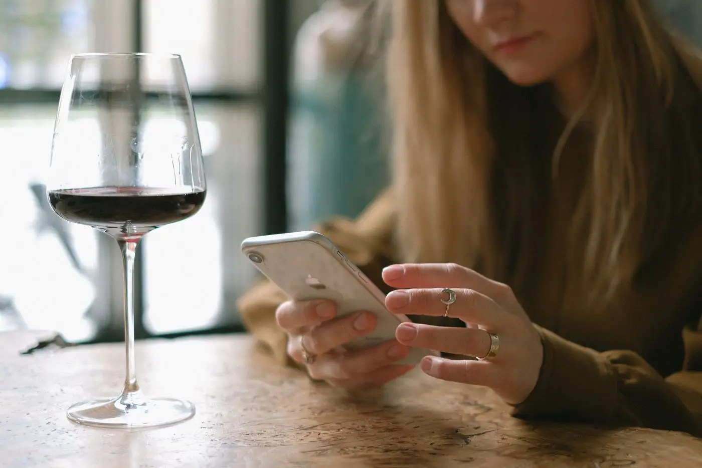 A smartphone in use at a restaurant table while service continues around it
